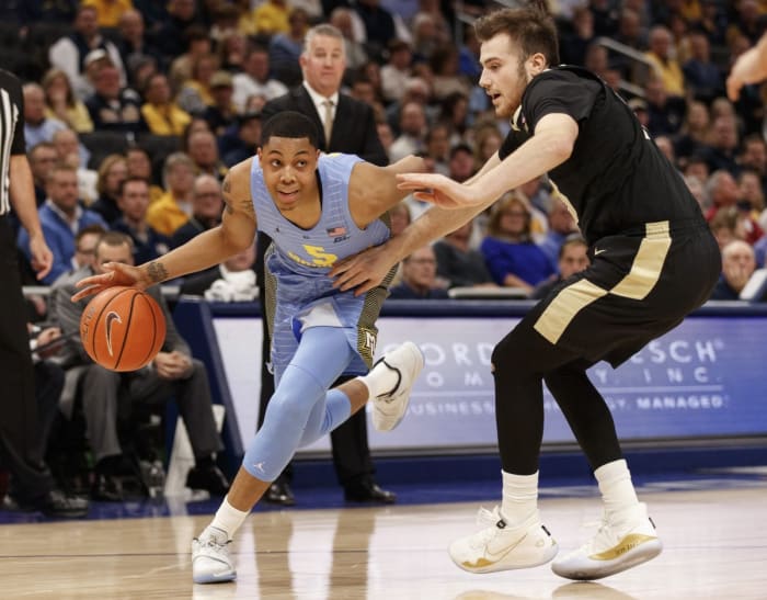 Marquette Golden Eagles guard Greg Elliott (5) drives for the basket around Purdue Boilermakers guard Sasha Stefanovic (55) during the first half at Fiserv Forum in Milwaukee, Wisconsin (2019).